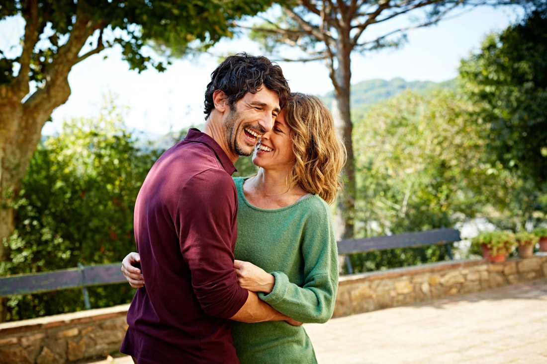 Cheerful couple embracing in park - life coaching and dating coaching