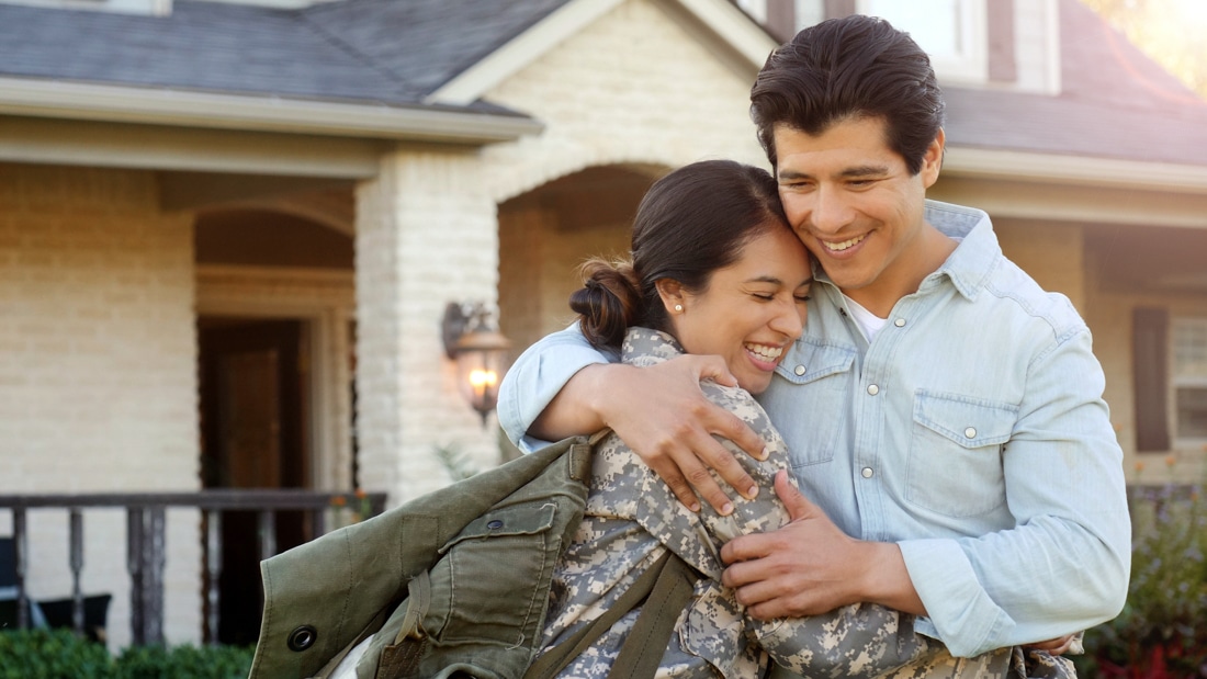 Photo of soldier returning home to spouse, representing Long distance couples therapy for military families.