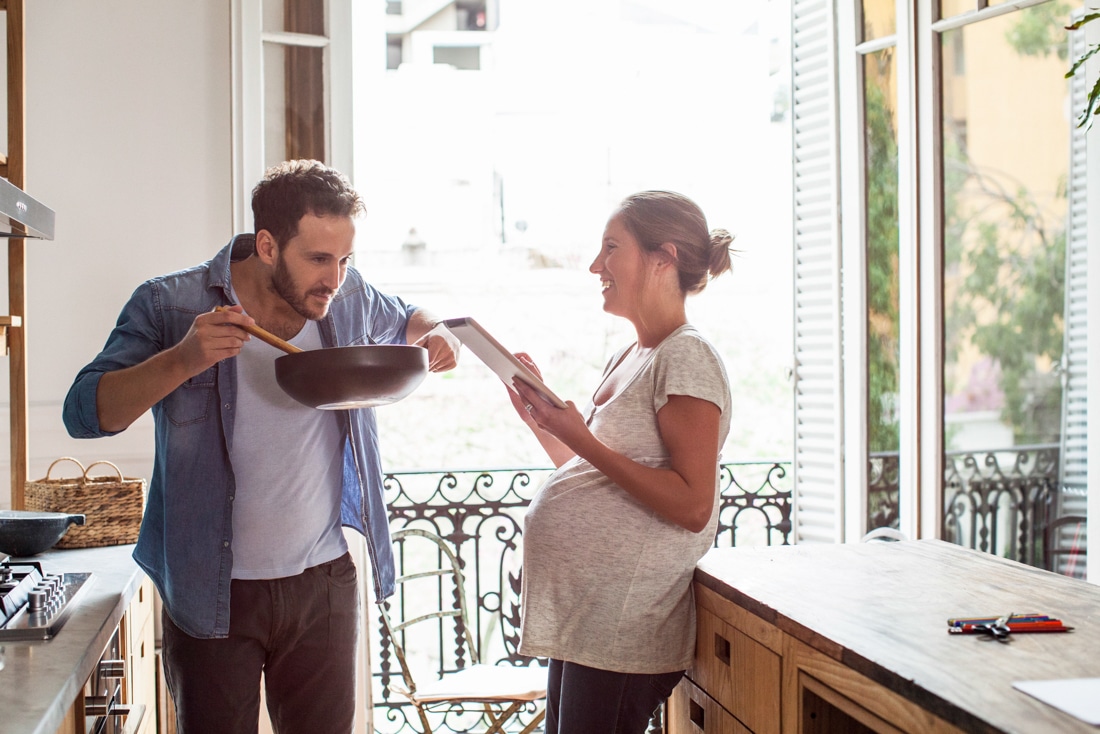 Husband and wife cooking at home, representing online premarital counseling