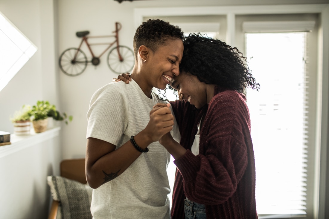 Lesbian couple dancing in living room