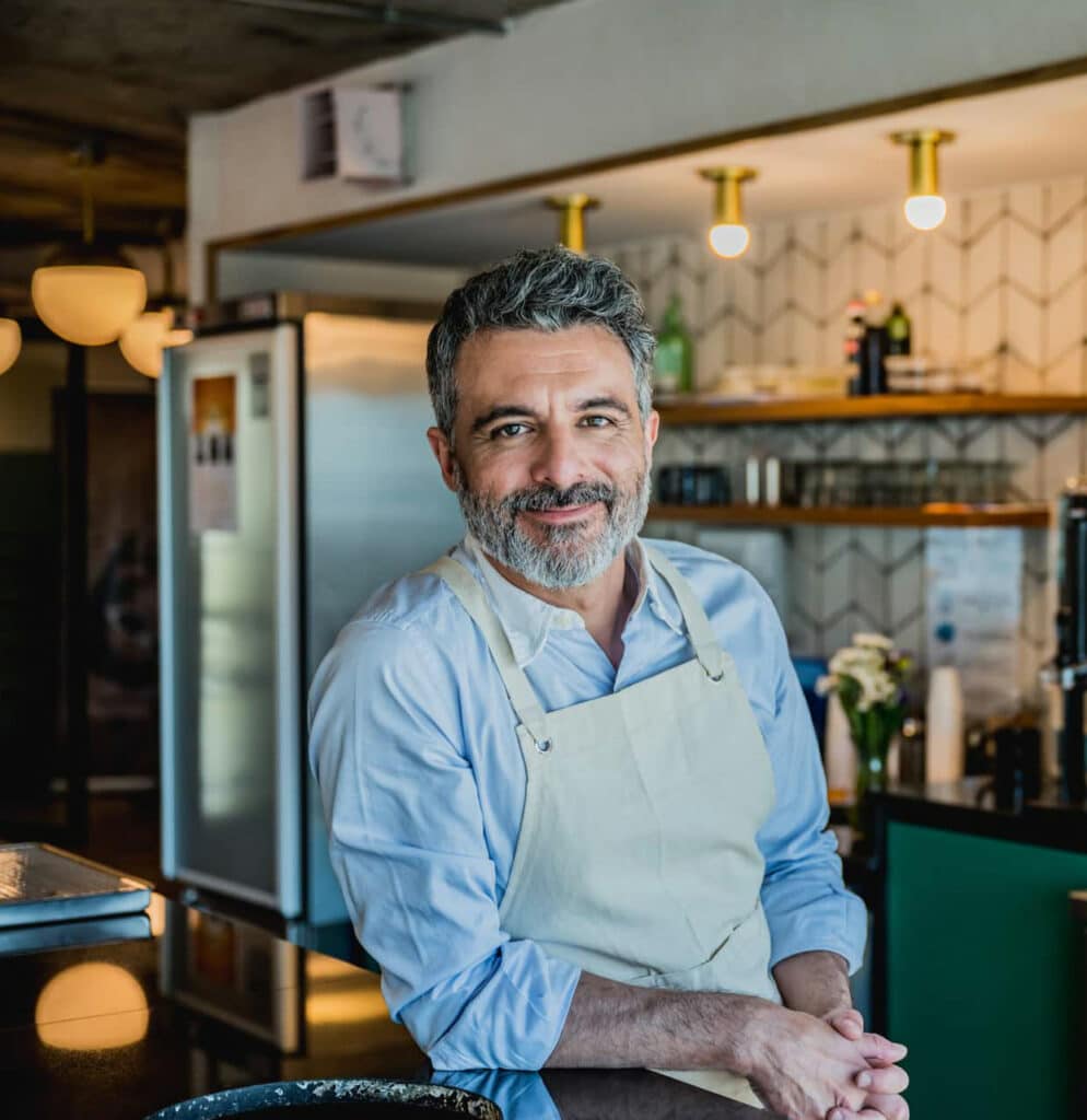 Smiling coffee shop owner operating his business.