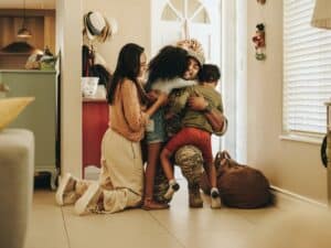 military relationships military dad coming home to embrace family in a hug