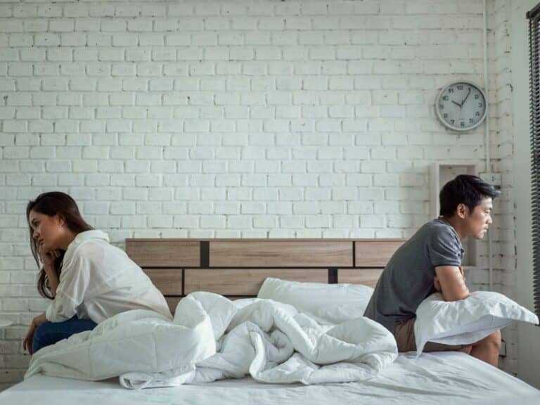 asian couple sitting on opposite sides of bed upset - so you cheated, now what