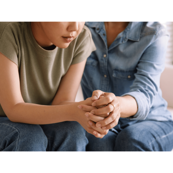 A woman comforts another woman representing how to help someone get help