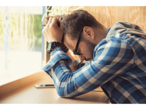Man with his head in his hands representing how to deal with regret