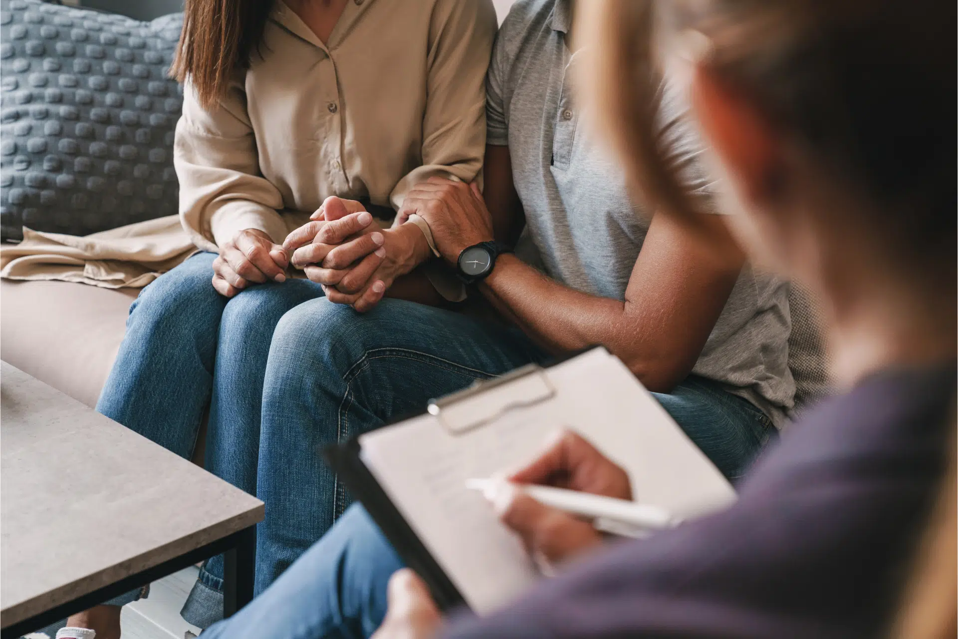 A counselor takes notes during a meeting with a couple representing what is an LMFT