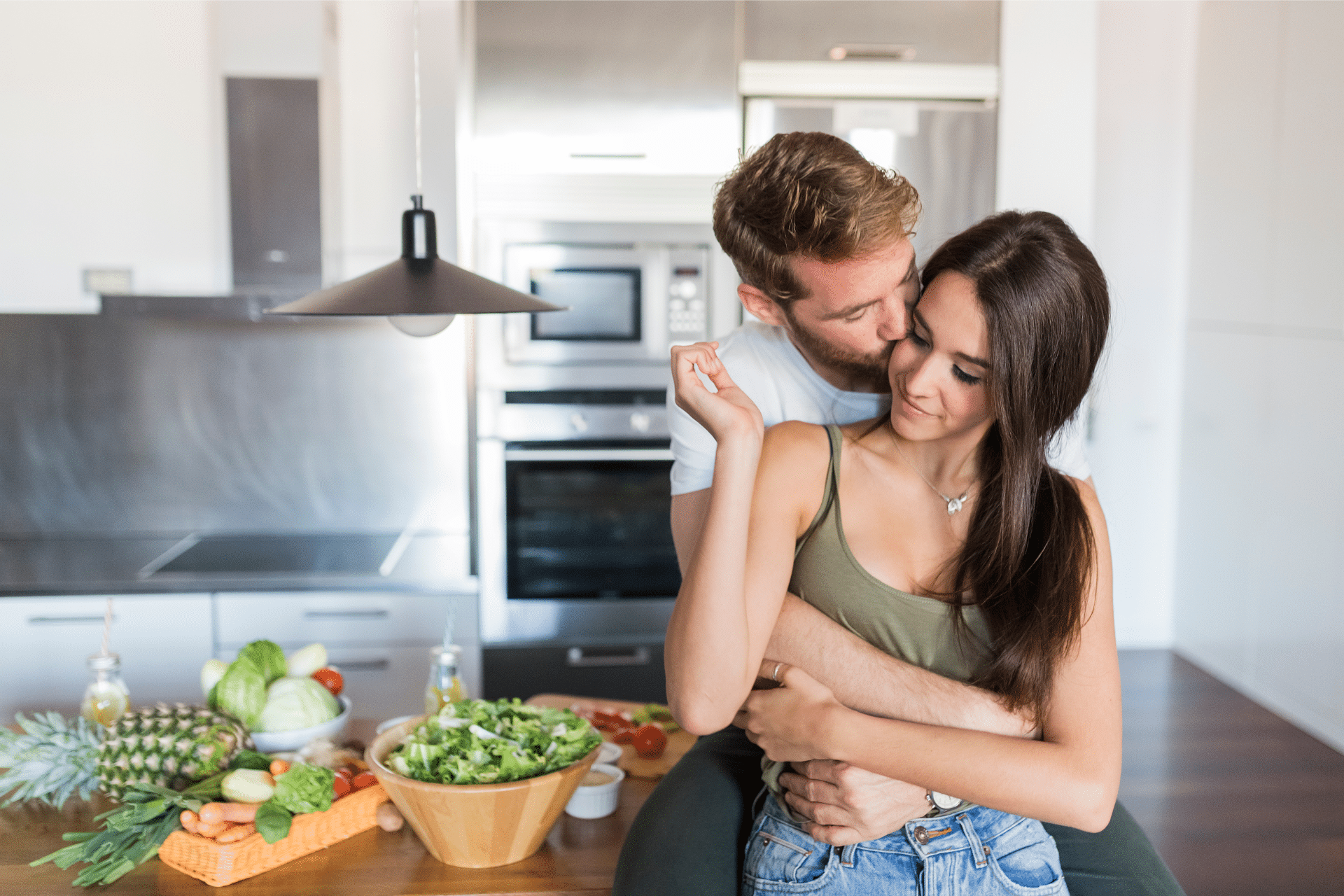 A couple hugs in the kitchen representing codependency versus interdependence.