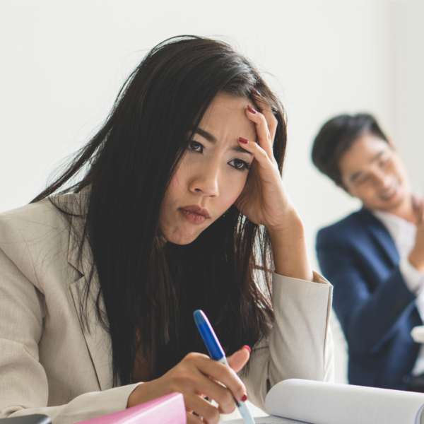 A woman holds her head in frustration representing how to deal with a difficult coworker