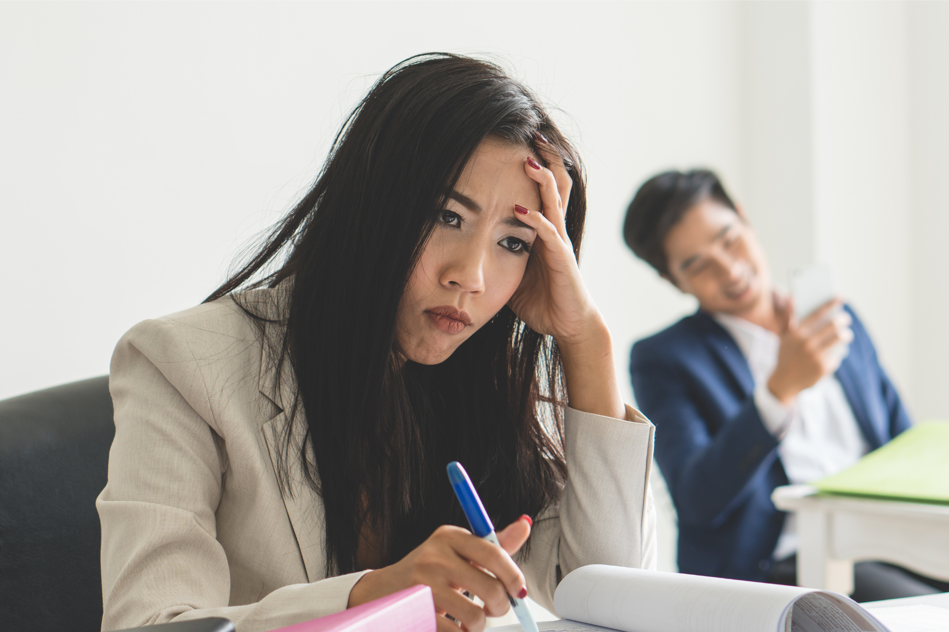 A woman holds her head in frustration representing how to deal with a difficult coworker