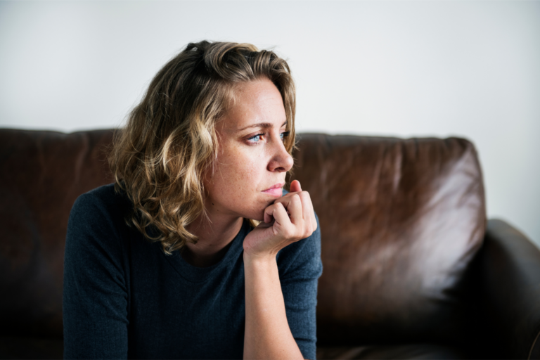 A woman stares off into the distance looking sad representing why you miss your ex