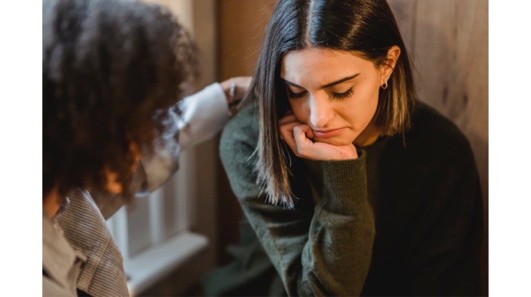A friend comforts a woman who looks upset representing emotional dumping