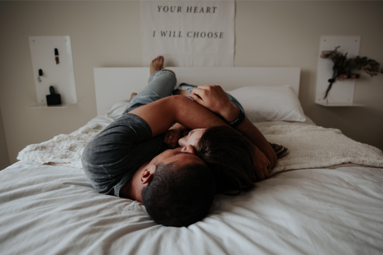 A couple cuddles in bed representing low sex drive ruining your relationship