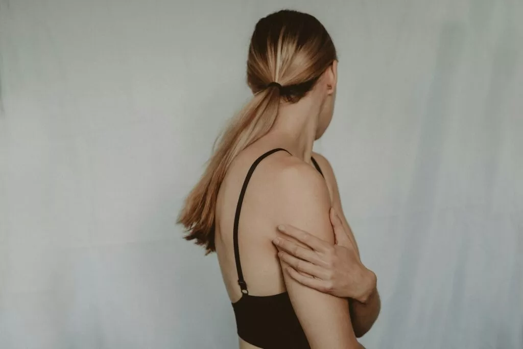 A woman turns her body away and protectively wraps her arm across her chest representing the bristle reaction.