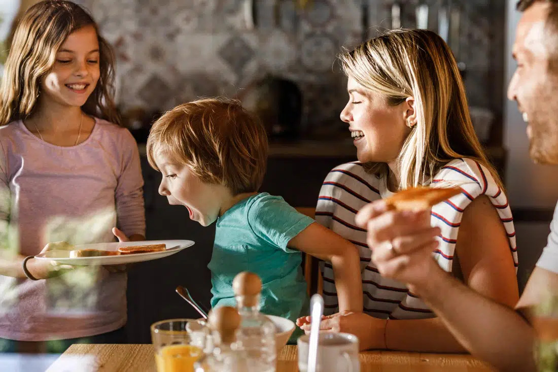 Happy family at dinner, representing successful blended family counseling.