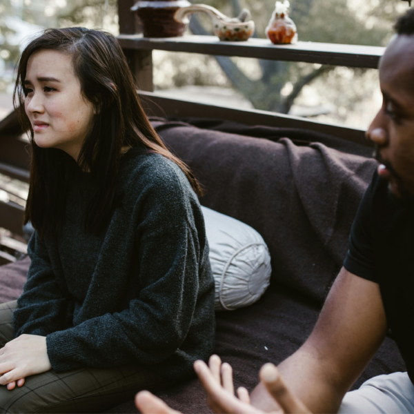 A man and a woman have an emotional conversation, representing being blindsided by a breakup