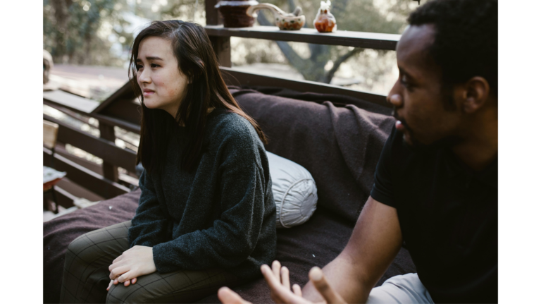 A man and a woman have an emotional conversation, representing being blindsided by a breakup