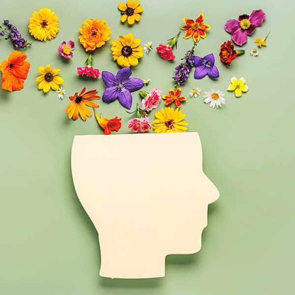 a paper cutout of the side profile of a head with flowers coming out of the top of it representing why therapists need to grow too.