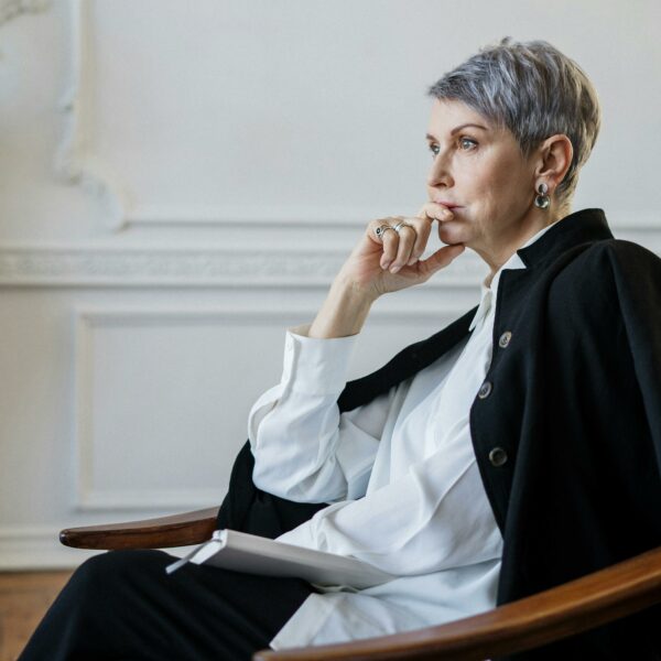 A female therapist sits in her office looking tired representing why therapists are so vulnerable to burnout.