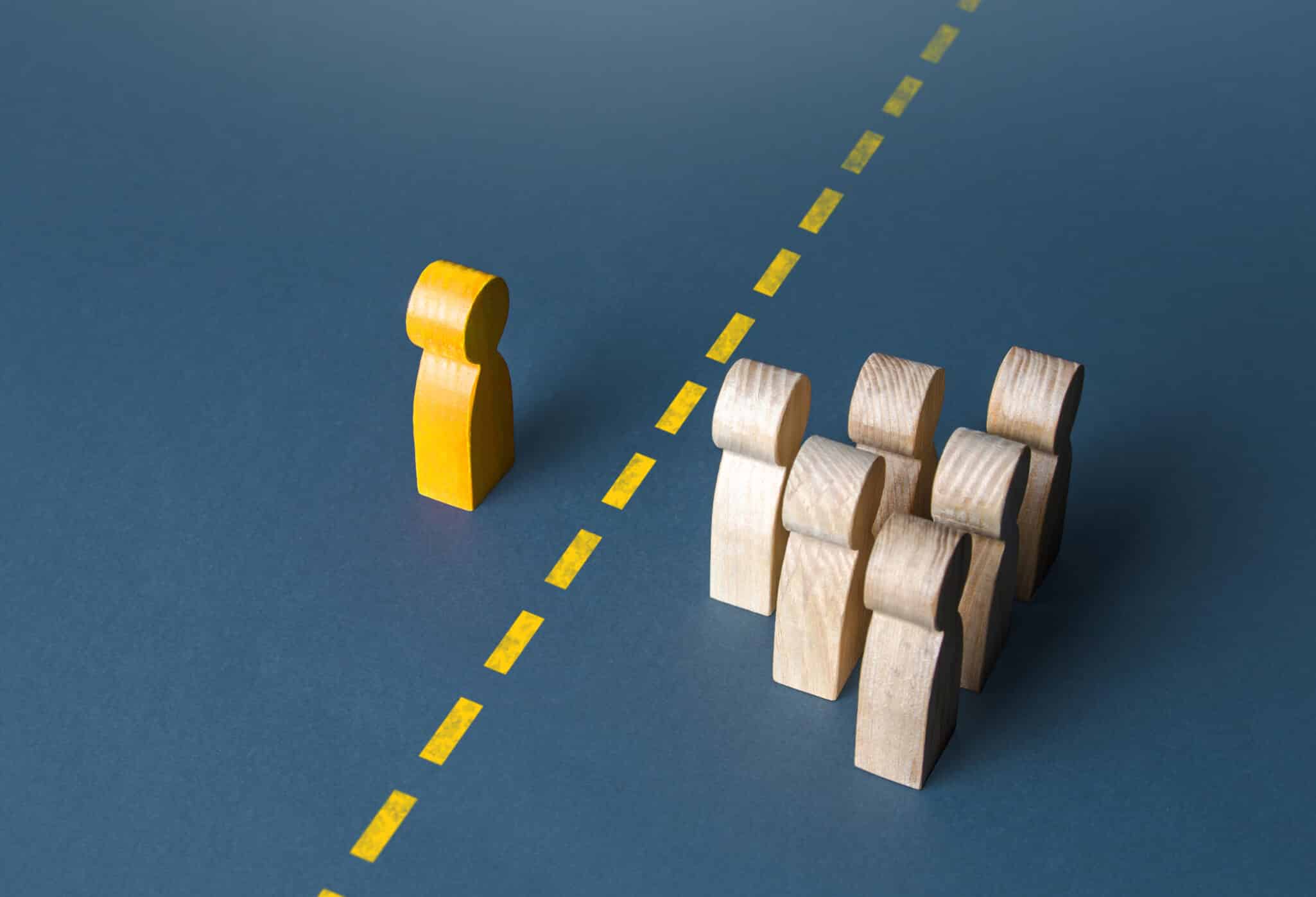 An abstract photo of a yellow figuring setting a boundary with multiple other figurings representing Therapeutic Boundaries for Therapists: Why Your Therapy Clients Think You're Weird