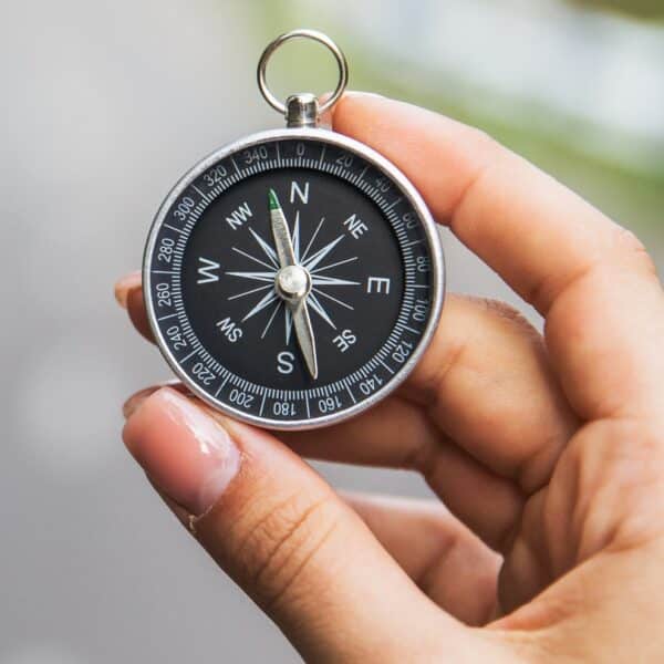 A woman is holding a compass representing Therapist Survival Guide: How to Dodge Ethical Landmines and Keep Your License Safe