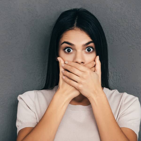 A therapist stands with her hands over her mouth representing Self-Disclosure in Therapy: How Much is Too Much?