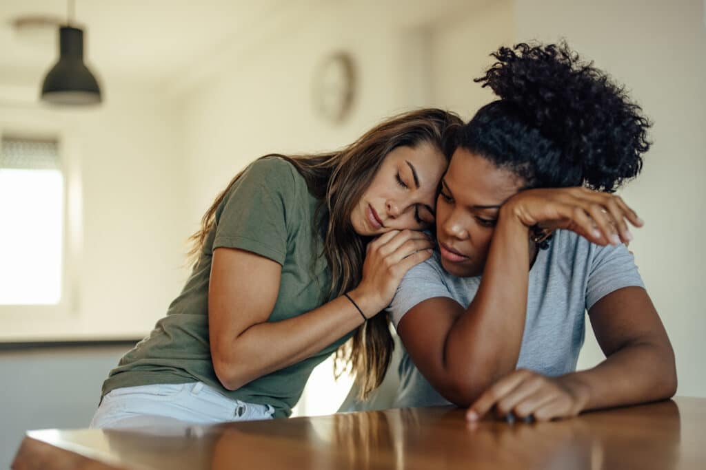 A woman is consoling her friend going through a hard time representing how You Can't Change People... But People Can Change.