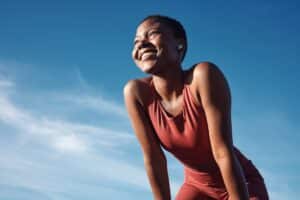 A woman looks happy and positive representing how to be a more positive person.