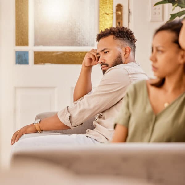 A couple sits apart from each other looking contemplative representing how to know when your marriage is over.