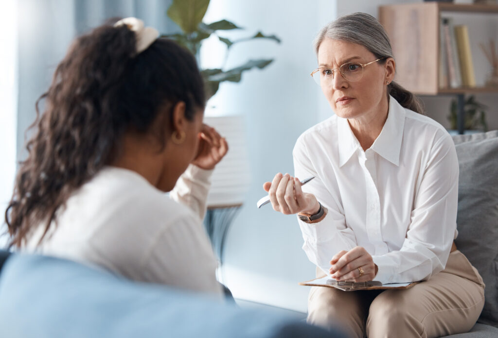 a therapist sits with a sad client in her office representing Can Therapists Give Advice?