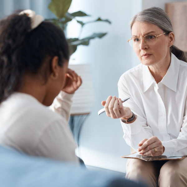 a therapist sits with a sad client in her office representing Can Therapists Give Advice?
