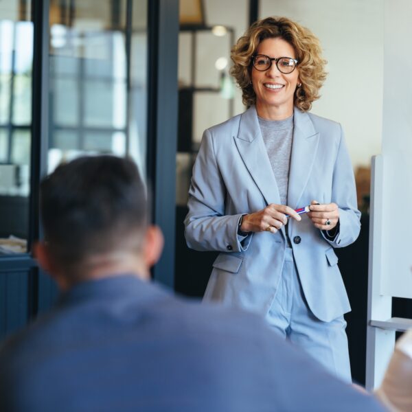 Confident woman leading a discussion about overcoming the likability trap and gender double standards.