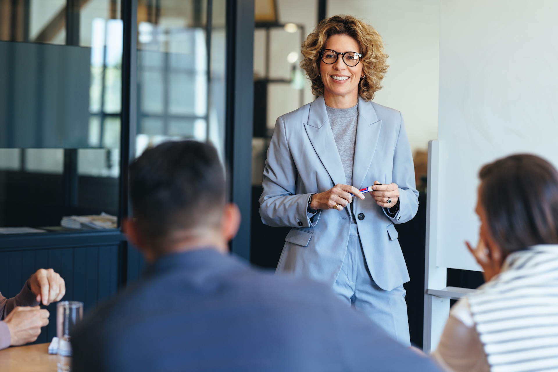 Confident woman leading a discussion about overcoming the likability trap and gender double standards.