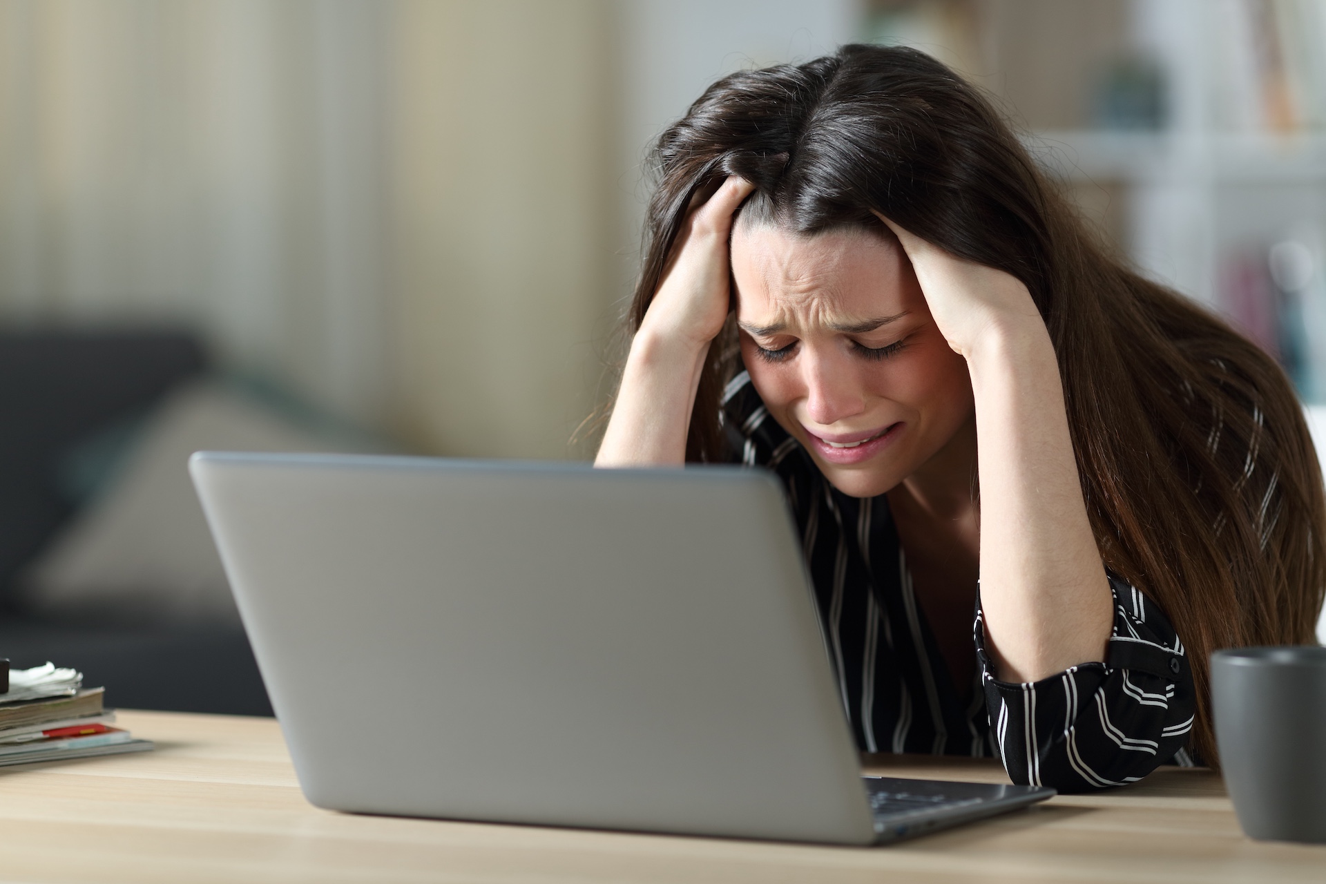 Stressed early career therapist crying in front of laptop during toxic mental health internship