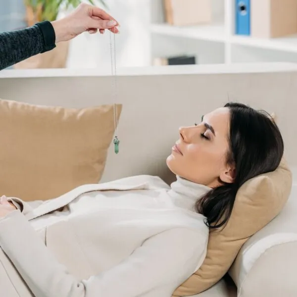 Woman practicing hypnosis with a therapist using a pendant, illustrating self-hypnosis techniques discussed by Dr. David Spiegel.