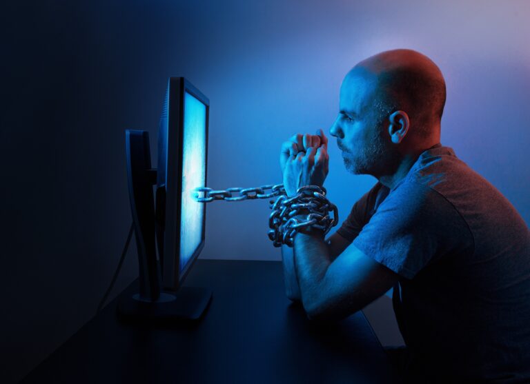 A man chained to a computer screen symbolizing porn addiction and its impact on relationships.