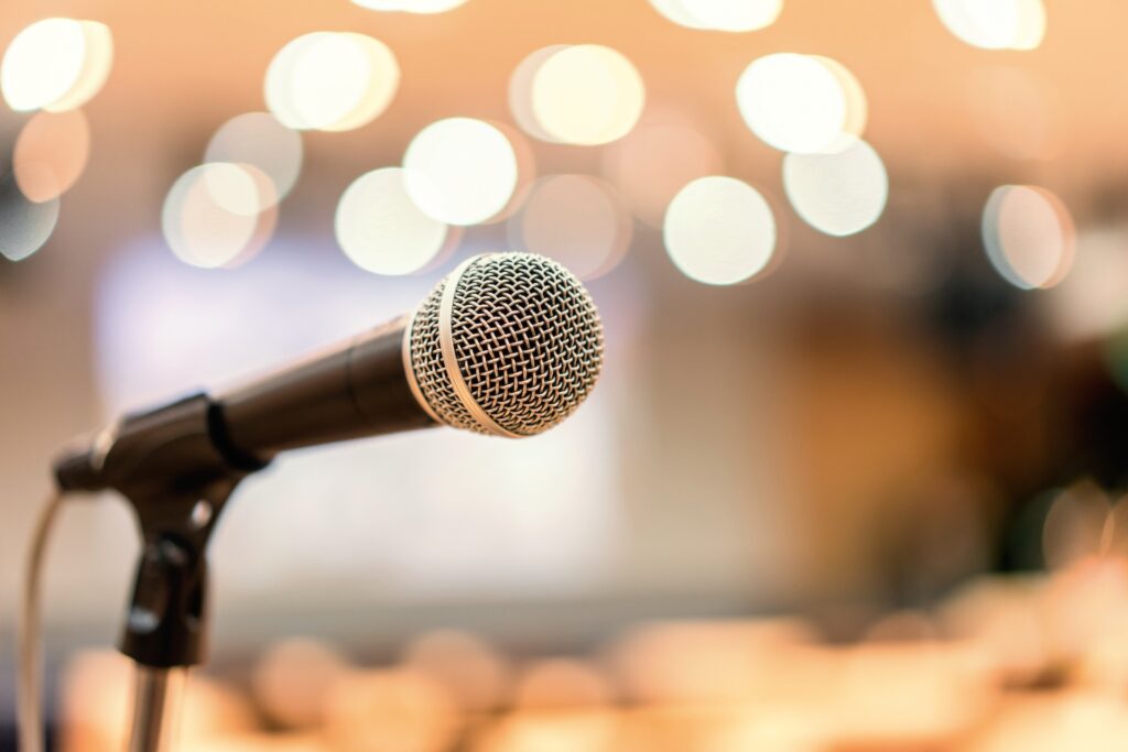 Close-up of a microphone on stage symbolizing therapists speaking out and advocating for systemic change in mental health.