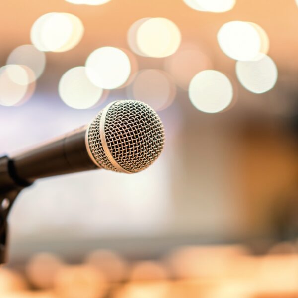 Close-up of a microphone on stage symbolizing therapists speaking out and advocating for systemic change in mental health.