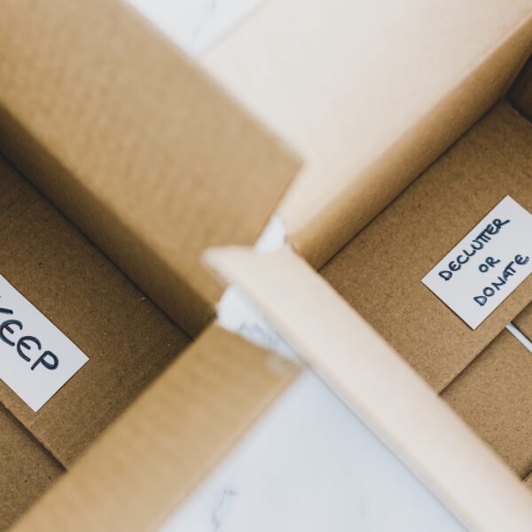 Open cardboard boxes labeled “Keep” and “Declutter or Donate,” representing the decluttering process to reduce overwhelm.