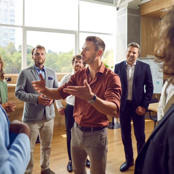 Organizational consultant leading a collaborative discussion with a group of business professionals in a bright, modern office.