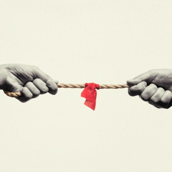 Hands pulling a rope in opposite directions with a red knot in the middle, representing how to negotiate with a narcissist and manage high-conflict relationship dynamics.