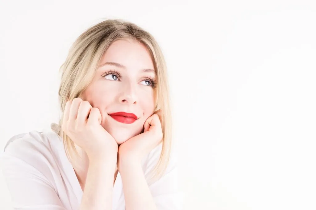 Woman gazing thoughtfully upward, illustrating limerence vs love and the experience of obsessive romantic longing.