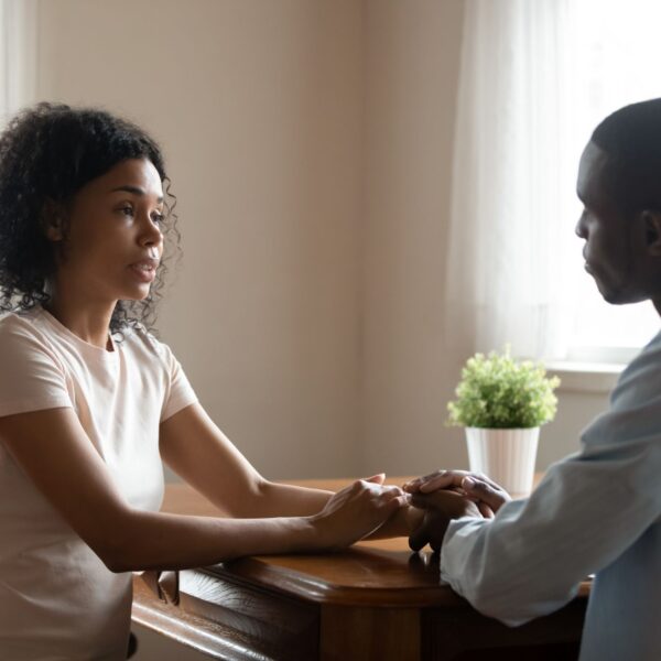 Couple having a serious conversation at a table, illustrating healthy communication and setting boundaries in a relationship