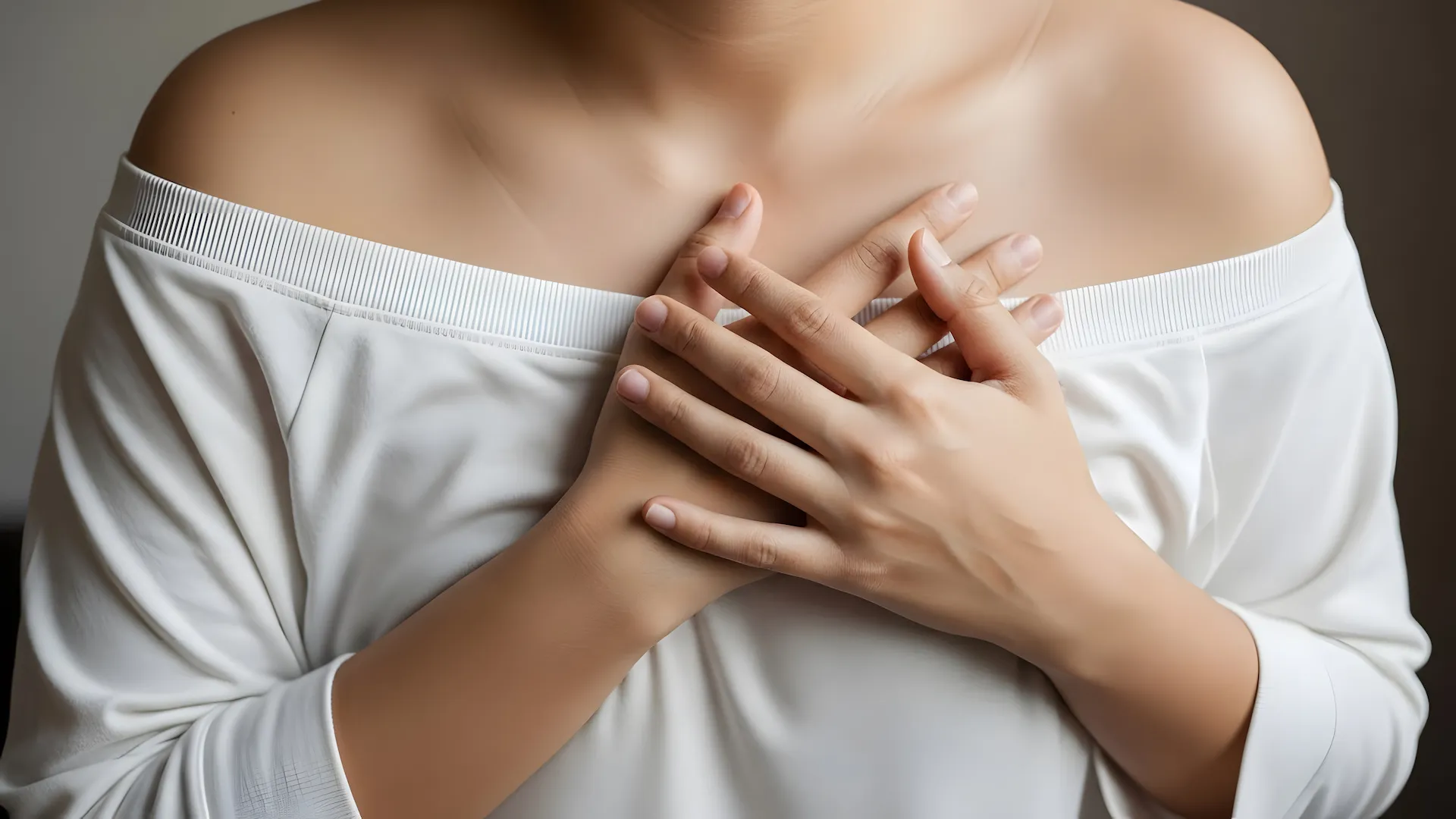 Person with both hands resting over their chest, illustrating somatic therapy, trauma healing, and embodied self-awareness.